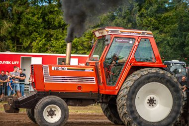 Aarhus, Danimarka. 16 Ağustos 2025 Güçlü makinelerin neşeli festival kalabalığından önce ağır topları çamura sürüklediği bir yarışma..