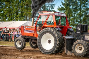 Aarhus, Danimarka. 16 Ağustos 2025 Güçlü makinelerin neşeli festival kalabalığından önce ağır topları çamura sürüklediği bir yarışma..