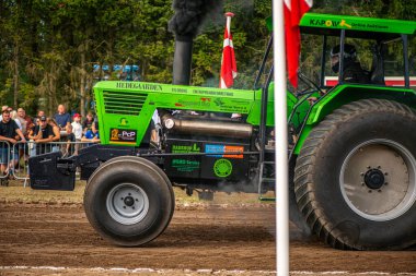 Aarhus, Danimarka. 16 Ağustos 2025 Güçlü makinelerin neşeli festival kalabalığından önce ağır topları çamura sürüklediği bir yarışma..