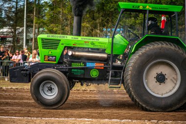 Aarhus, Danimarka. 16 Ağustos 2025 Güçlü makinelerin neşeli festival kalabalığından önce ağır topları çamura sürüklediği bir yarışma..
