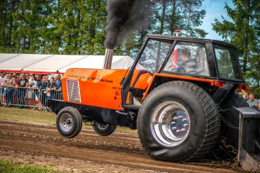 Aarhus, Danimarka. 16 Ağustos 2025 Güçlü makinelerin neşeli festival kalabalığından önce ağır topları çamura sürüklediği bir yarışma..