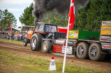 Aarhus, Danimarka. 16 Ağustos 2025 Güçlü makinelerin neşeli festival kalabalığından önce ağır topları çamura sürüklediği bir yarışma..