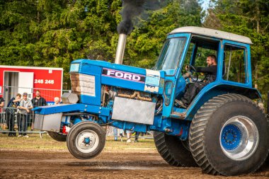 Aarhus, Danimarka. 16 Ağustos 2025 Güçlü makinelerin neşeli festival kalabalığından önce ağır topları çamura sürüklediği bir yarışma..