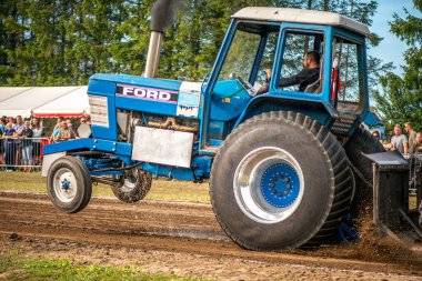 Aarhus, Danimarka. 16 Ağustos 2025 Güçlü makinelerin neşeli festival kalabalığından önce ağır topları çamura sürüklediği bir yarışma..