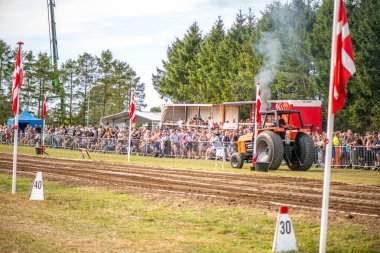 Aarhus, Danimarka. 16 Ağustos 2025 Güçlü makinelerin neşeli festival kalabalığından önce ağır topları çamura sürüklediği bir yarışma..