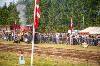 Aarhus, Danimarka. 16 Ağustos 2025 Güçlü makinelerin neşeli festival kalabalığından önce ağır topları çamura sürüklediği bir yarışma..