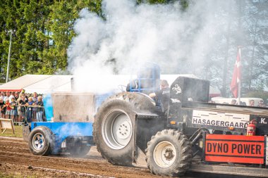 Aarhus, Danimarka. 16 Ağustos 2025 Güçlü makinelerin neşeli festival kalabalığından önce ağır topları çamura sürüklediği bir yarışma..
