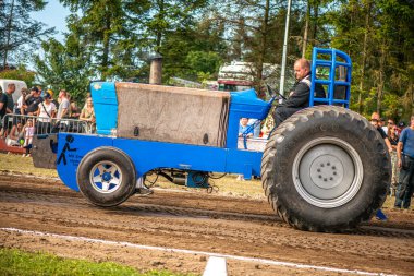 Aarhus, Danimarka. 16 Ağustos 2025 Güçlü makinelerin neşeli festival kalabalığından önce ağır topları çamura sürüklediği bir yarışma..