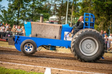 Aarhus, Danimarka. 16 Ağustos 2025 Güçlü makinelerin neşeli festival kalabalığından önce ağır topları çamura sürüklediği bir yarışma..