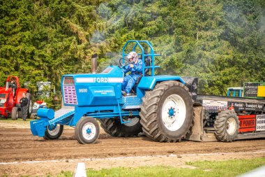 Aarhus, Danimarka. 16 Ağustos 2025 Güçlü makinelerin neşeli festival kalabalığından önce ağır topları çamura sürüklediği bir yarışma..