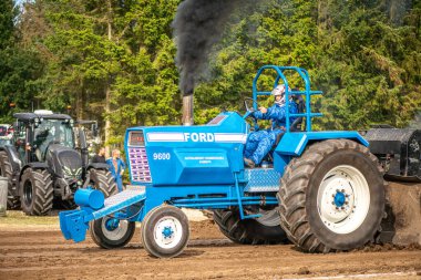 Aarhus, Danimarka. 16 Ağustos 2025 Güçlü makinelerin neşeli festival kalabalığından önce ağır topları çamura sürüklediği bir yarışma..
