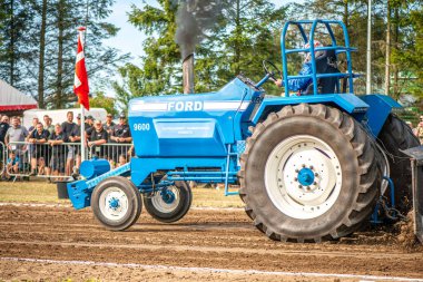 Aarhus, Danimarka. 16 Ağustos 2025 Güçlü makinelerin neşeli festival kalabalığından önce ağır topları çamura sürüklediği bir yarışma..