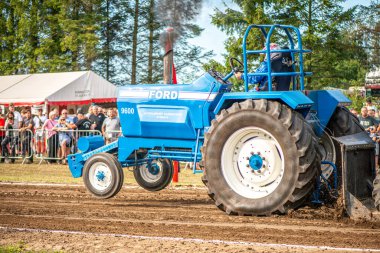 Aarhus, Danimarka. 16 Ağustos 2025 Güçlü makinelerin neşeli festival kalabalığından önce ağır topları çamura sürüklediği bir yarışma..