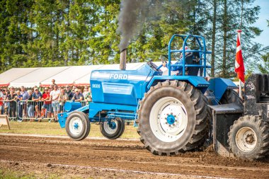 Aarhus, Danimarka. 16 Ağustos 2025 Güçlü makinelerin neşeli festival kalabalığından önce ağır topları çamura sürüklediği bir yarışma..