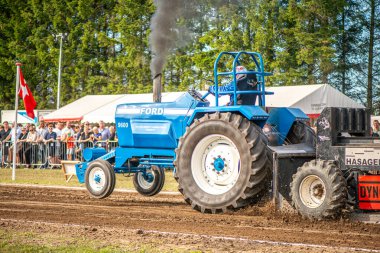 Aarhus, Danimarka. 16 Ağustos 2025 Güçlü makinelerin neşeli festival kalabalığından önce ağır topları çamura sürüklediği bir yarışma..
