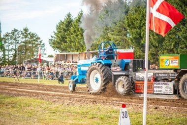 Aarhus, Danimarka. 16 Ağustos 2025 Güçlü makinelerin neşeli festival kalabalığından önce ağır topları çamura sürüklediği bir yarışma..