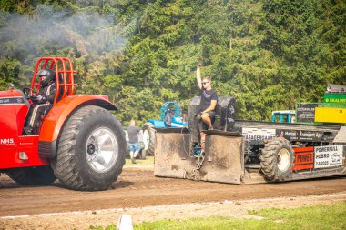 Aarhus, Danimarka. 16 Ağustos 2025 Güçlü makinelerin neşeli festival kalabalığından önce ağır topları çamura sürüklediği bir yarışma..