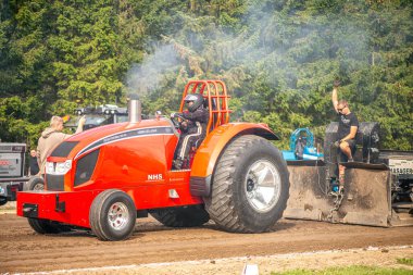 Aarhus, Danimarka. 16 Ağustos 2025 Güçlü makinelerin neşeli festival kalabalığından önce ağır topları çamura sürüklediği bir yarışma..