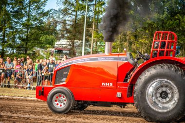 Aarhus, Danimarka. 16 Ağustos 2025 Güçlü makinelerin neşeli festival kalabalığından önce ağır topları çamura sürüklediği bir yarışma..