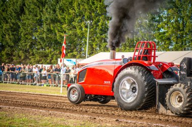 Aarhus, Danimarka. 16 Ağustos 2025 Güçlü makinelerin neşeli festival kalabalığından önce ağır topları çamura sürüklediği bir yarışma..