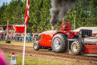 Aarhus, Danimarka. 16 Ağustos 2025 Güçlü makinelerin neşeli festival kalabalığından önce ağır topları çamura sürüklediği bir yarışma..