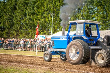 Aarhus, Danimarka. 16 Ağustos 2025 Güçlü makinelerin neşeli festival kalabalığından önce ağır topları çamura sürüklediği bir yarışma..
