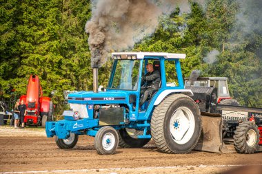 Aarhus, Danimarka. 16 Ağustos 2025 Güçlü makinelerin neşeli festival kalabalığından önce ağır topları çamura sürüklediği bir yarışma..