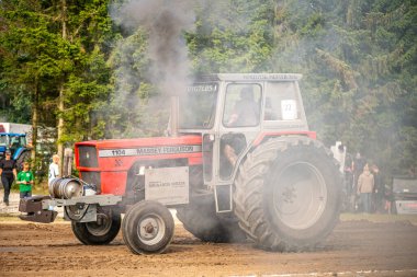 Aarhus, Danimarka. 16 Ağustos 2025 Güçlü makinelerin neşeli festival kalabalığından önce ağır topları çamura sürüklediği bir yarışma..