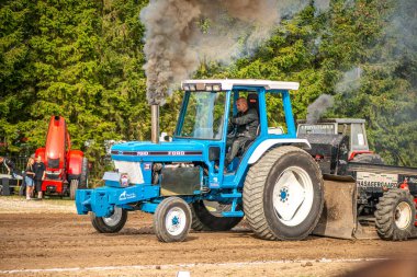Aarhus, Danimarka. 16 Ağustos 2025 Güçlü makinelerin neşeli festival kalabalığından önce ağır topları çamura sürüklediği bir yarışma..