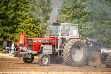 Aarhus, Danimarka. 16 Ağustos 2025 Güçlü makinelerin neşeli festival kalabalığından önce ağır topları çamura sürüklediği bir yarışma..