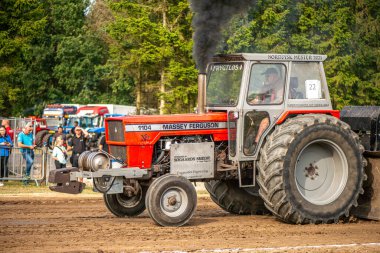 Aarhus, Danimarka. 16 Ağustos 2025 Güçlü makinelerin neşeli festival kalabalığından önce ağır topları çamura sürüklediği bir yarışma..