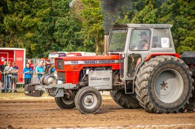 Aarhus, Danimarka. 16 Ağustos 2025 Güçlü makinelerin neşeli festival kalabalığından önce ağır topları çamura sürüklediği bir yarışma..