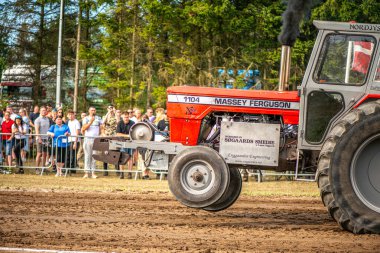Aarhus, Danimarka. 16 Ağustos 2025 Güçlü makinelerin neşeli festival kalabalığından önce ağır topları çamura sürüklediği bir yarışma..