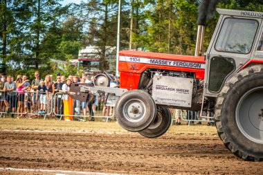 Aarhus, Danimarka. 16 Ağustos 2025 Güçlü makinelerin neşeli festival kalabalığından önce ağır topları çamura sürüklediği bir yarışma..