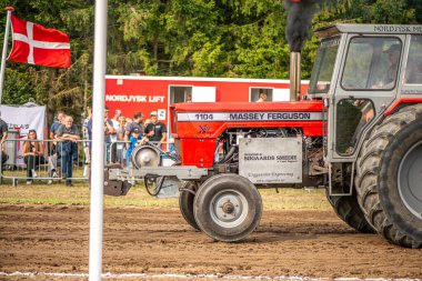 Aarhus, Danimarka. 16 Ağustos 2025 Güçlü makinelerin neşeli festival kalabalığından önce ağır topları çamura sürüklediği bir yarışma..