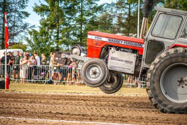 Aarhus, Danimarka. 16 Ağustos 2025 Güçlü makinelerin neşeli festival kalabalığından önce ağır topları çamura sürüklediği bir yarışma..