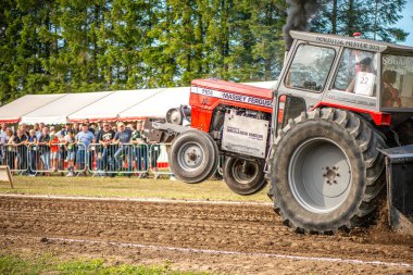 Aarhus, Danimarka. 16 Ağustos 2025 Güçlü makinelerin neşeli festival kalabalığından önce ağır topları çamura sürüklediği bir yarışma..