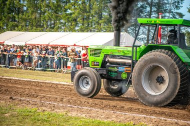 Aarhus, Danimarka. 16 Ağustos 2025 Güçlü makinelerin neşeli festival kalabalığından önce ağır topları çamura sürüklediği bir yarışma..