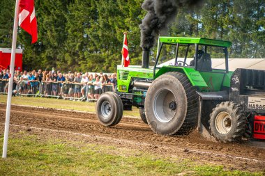 Aarhus, Danimarka. 16 Ağustos 2025 Güçlü makinelerin neşeli festival kalabalığından önce ağır topları çamura sürüklediği bir yarışma..