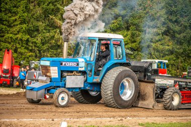 Aarhus, Danimarka. 16 Ağustos 2025 Güçlü makinelerin neşeli festival kalabalığından önce ağır topları çamura sürüklediği bir yarışma..