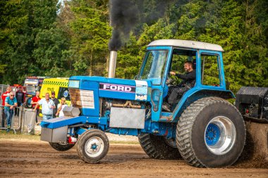 Aarhus, Danimarka. 16 Ağustos 2025 Güçlü makinelerin neşeli festival kalabalığından önce ağır topları çamura sürüklediği bir yarışma..
