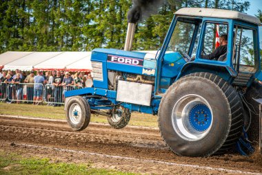 Aarhus, Danimarka. 16 Ağustos 2025 Güçlü makinelerin neşeli festival kalabalığından önce ağır topları çamura sürüklediği bir yarışma..