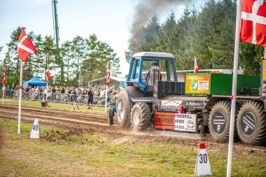 Aarhus, Danimarka. 16 Ağustos 2025 Güçlü makinelerin neşeli festival kalabalığından önce ağır topları çamura sürüklediği bir yarışma..