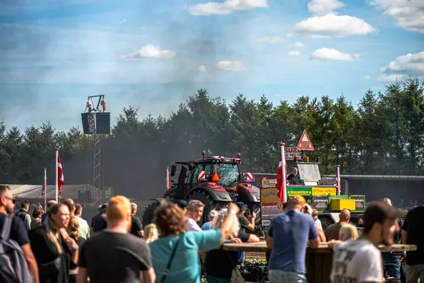 Aarhus, Danimarka. 16 Ağustos 2025 Güçlü makinelerin neşeli festival kalabalığından önce ağır topları çamura sürüklediği bir yarışma..