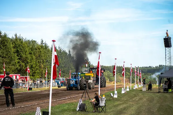 Aarhus, Danimarka. 16 Ağustos 2025 Güçlü makinelerin neşeli festival kalabalığından önce ağır topları çamura sürüklediği bir yarışma..