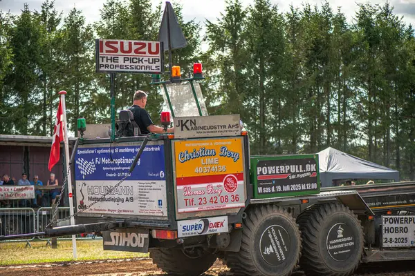Aarhus, Danimarka. 16 Ağustos 2025 Güçlü makinelerin neşeli festival kalabalığından önce ağır topları çamura sürüklediği bir yarışma..