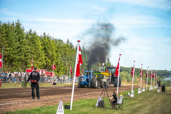 Aarhus, Danimarka. 16 Ağustos 2025 Güçlü makinelerin neşeli festival kalabalığından önce ağır topları çamura sürüklediği bir yarışma..