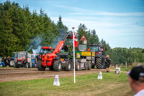 Aarhus, Danimarka. 16 Ağustos 2025 Güçlü makinelerin neşeli festival kalabalığından önce ağır topları çamura sürüklediği bir yarışma..