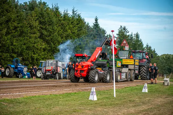 Aarhus, Danimarka. 16 Ağustos 2025 Güçlü makinelerin neşeli festival kalabalığından önce ağır topları çamura sürüklediği bir yarışma..