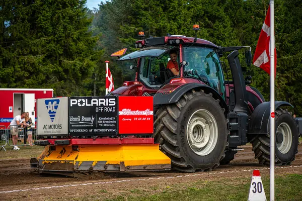 Aarhus, Danimarka. 16 Ağustos 2025 Güçlü makinelerin neşeli festival kalabalığından önce ağır topları çamura sürüklediği bir yarışma..